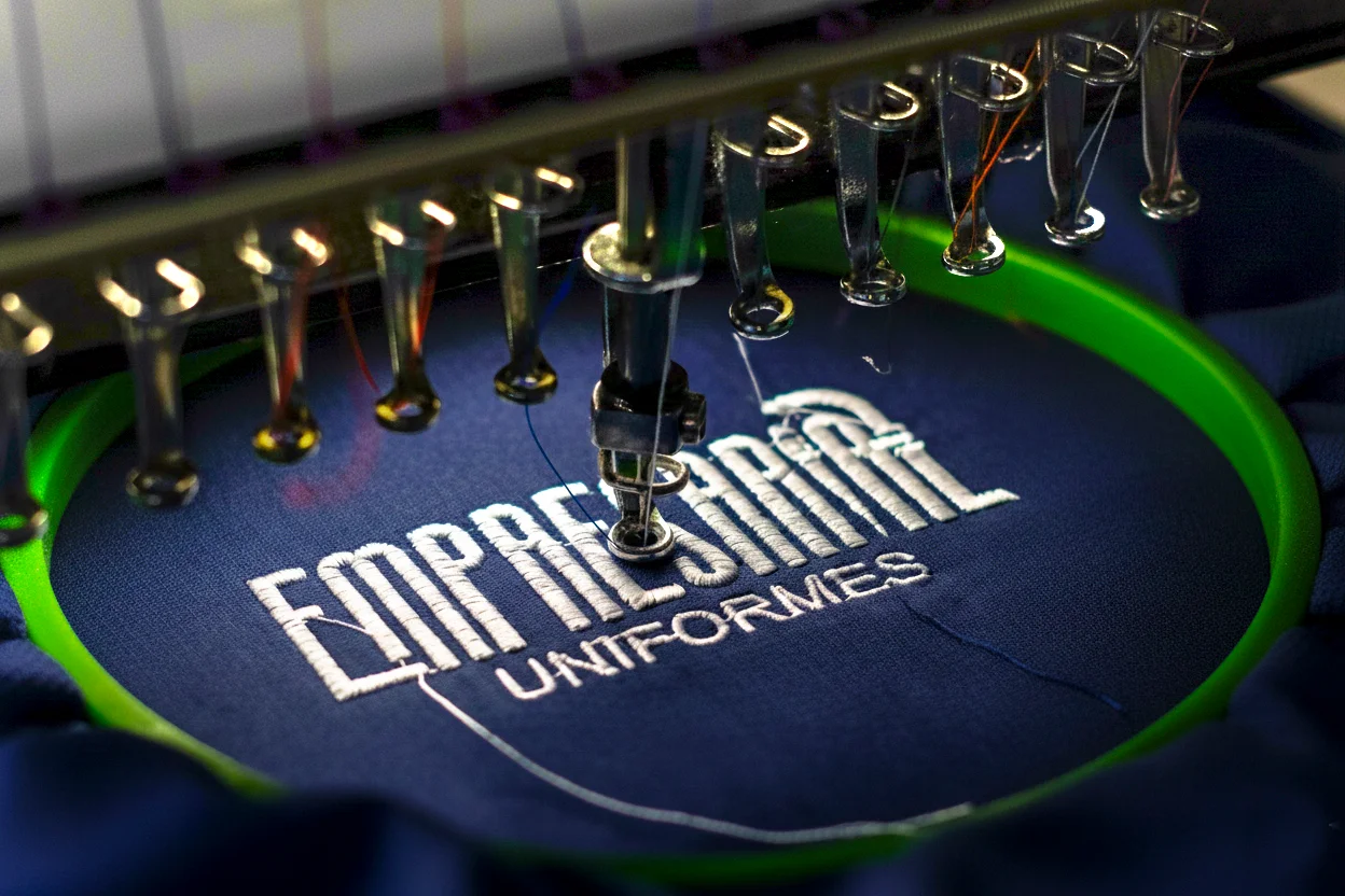 Logo Empresarial Uniformes sendo bordado